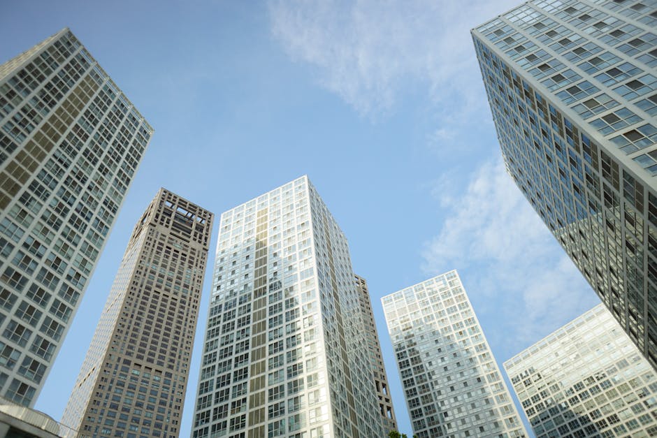 Low angle shot of modern skyscrapers in Beijing, showcasing architecture against a clear blue sky.