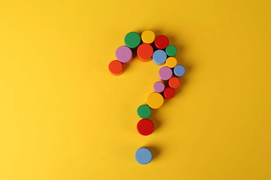 A vibrant question mark made from colorful circular blocks on a yellow background, symbolizing curiosity and inquiry.