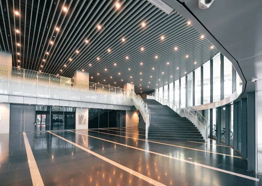 Spacious modern office interior with elegant spiral staircase and ceiling lights.